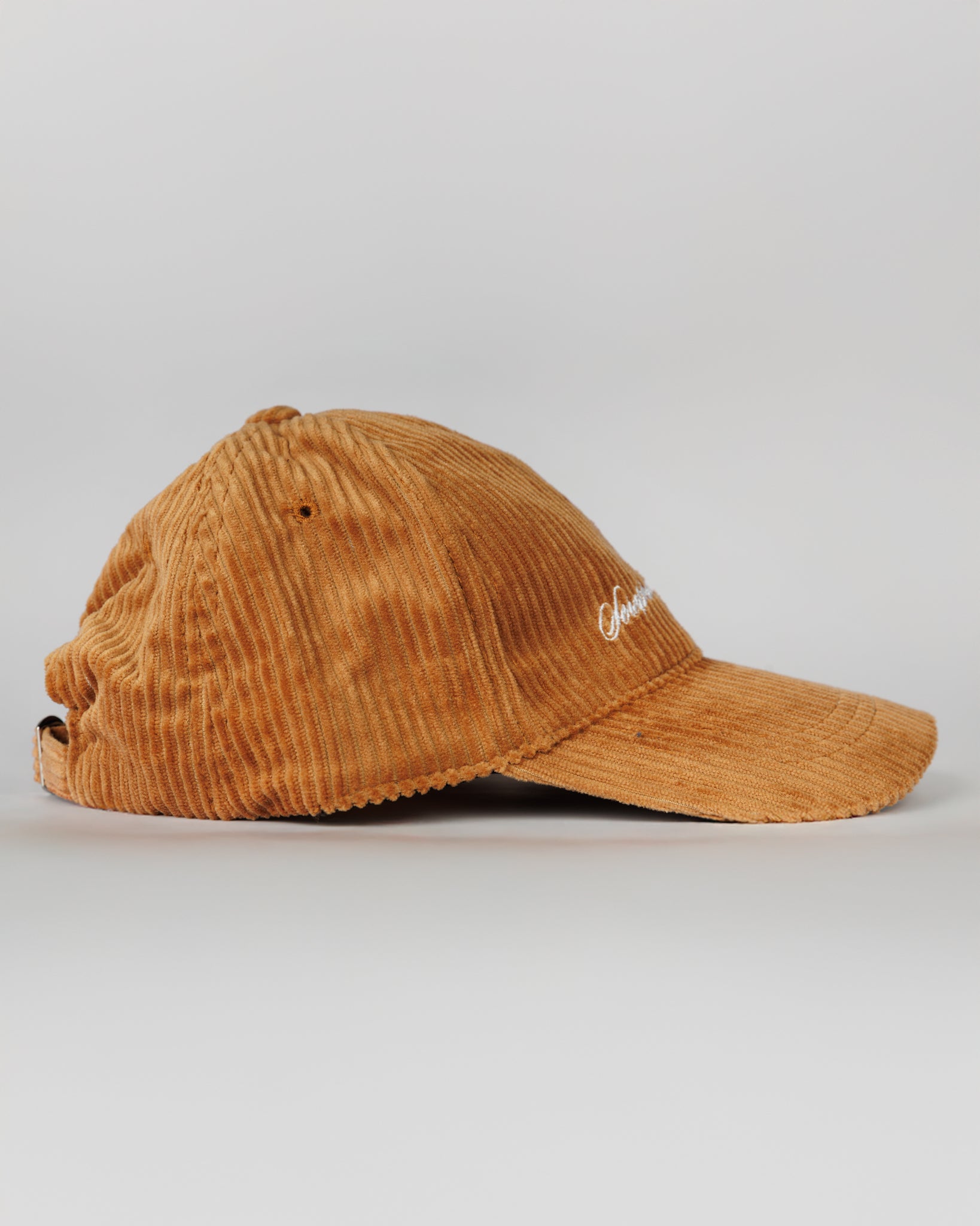 Brown corduroy cap with a logo on a light gray background
