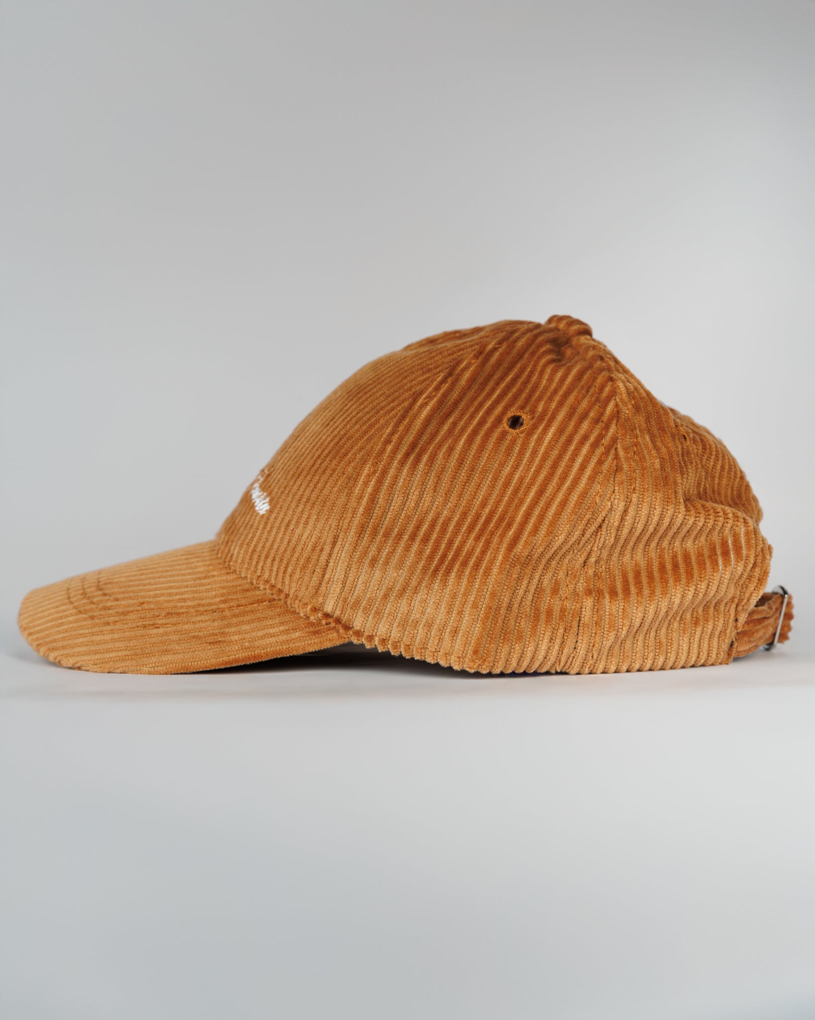 Brown corduroy cap on a light gray background